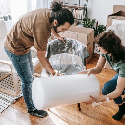 dos personas embalando con papel de burbuja mueble frágil